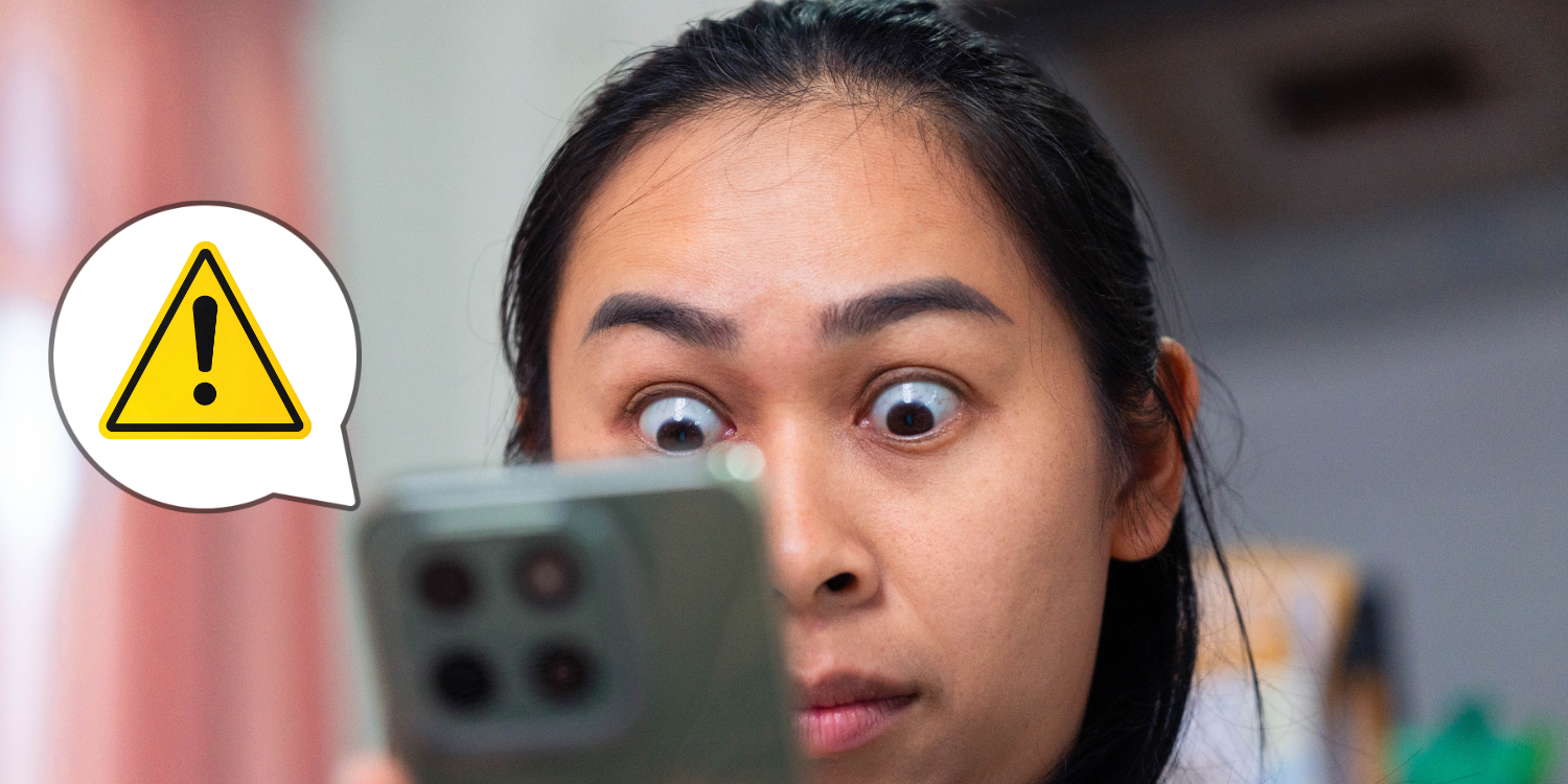 person holding a smartphone with alert box 